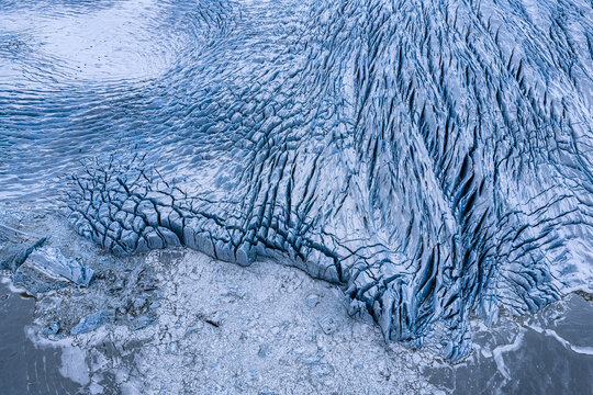 Aerial view of Fjallsarlon glacier with deep blue crevasses and ice formations meeting the glacial lagoon, Sveitarfelagid Hornafjordur, Iceland.
