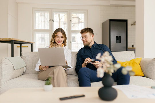 Couple working on laptop during coffee break in home office