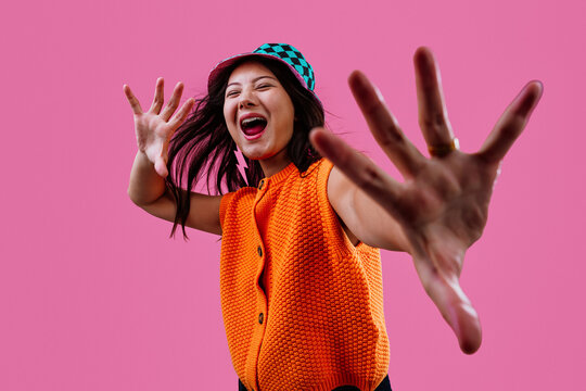 Young woman playfully reaching out with hands to camera