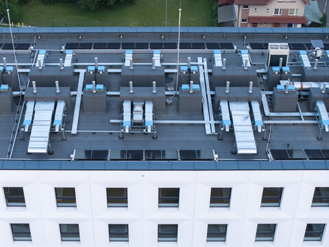 Aerial view of HVAC ventilation units and solar panels installed on the flat roof of a modern office building in Krakow, Lesser Poland Voivode, Poland.