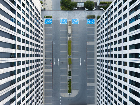 Aerial view of modern office buildings flanking a parking lot with marked spaces and green dividers in Krakow, Lesser Poland Voivode, Poland.