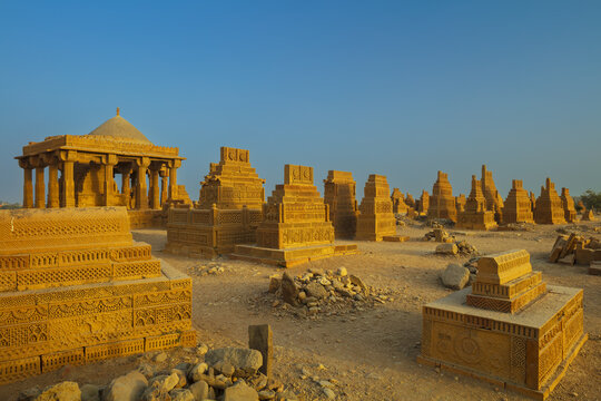 View of the historic Chaukhandi Tombs with intricately carved sandstone structures under a clear blue sky in Karachi, Sindh, Pakistan.