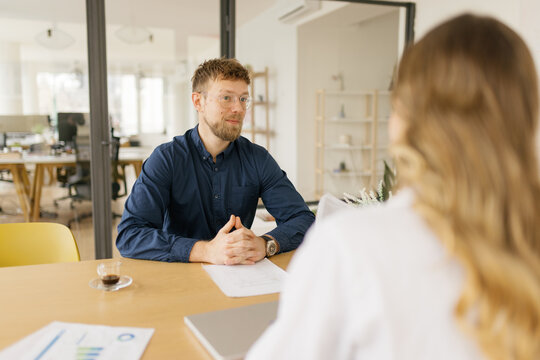 Male manager interviews female candidate at the office desk