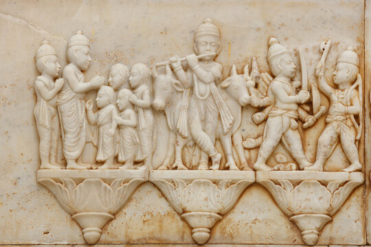 View of marble relief carving depicting Lord Krishna playing the flute with cows and other figures at Sadhu Bela Mandir in Rohri, Sindh, Pakistan.