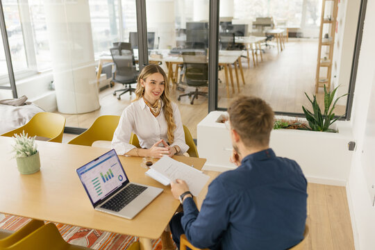 Businessman and businesswoman analyzing financial chart in the office