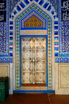 View of the ornate entrance door at the Shrine of Shah Abdul Latif Bhittai featuring intricate blue and white tile work and geometric patterns in Bhit Shah, Sindh, Pakistan.
