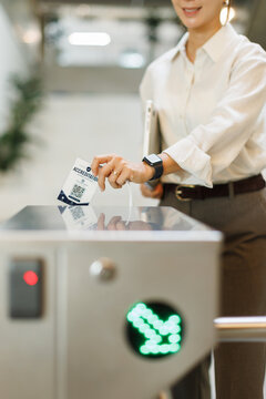Businesswoman scanning access card at office building turnstile