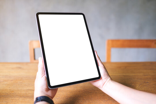 Mockup image of a woman holding digital tablet with blank white desktop screen