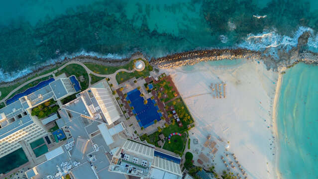 Aerial view of the resort with a large swimming pool, white sand beach, and turquoise Caribbean sea in Cancun, Quintana Roo, Mexico.