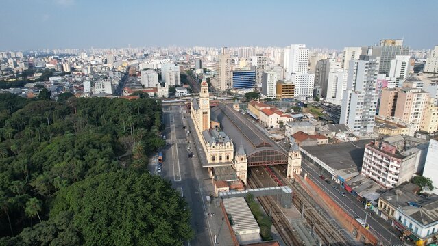 Aerial view of Luz Station with its iconic clock tower, surrounded by urban cityscape, lush parkland, and railway tracks in Sao Paulo, State of Sao Paulo, Brazil.