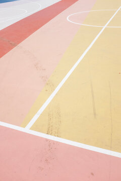 Colourful urban basketball court has painted lines and dirt marks