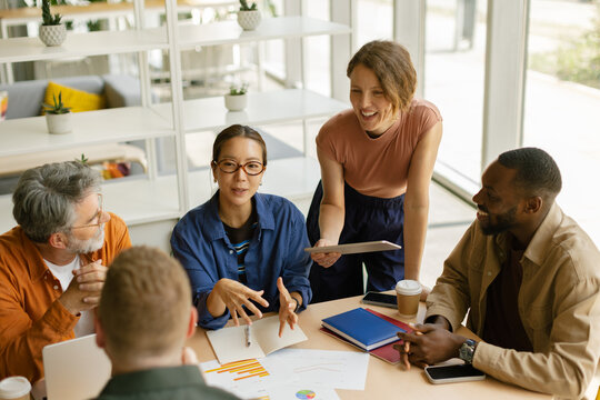 Smiling business team plans future startup in modern office