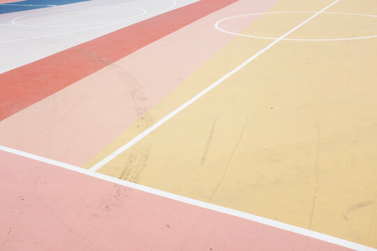 Colorful lines mark an empty urban basketball court outdoors