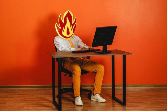 Businessman with fire mask working at office desk showing burnout