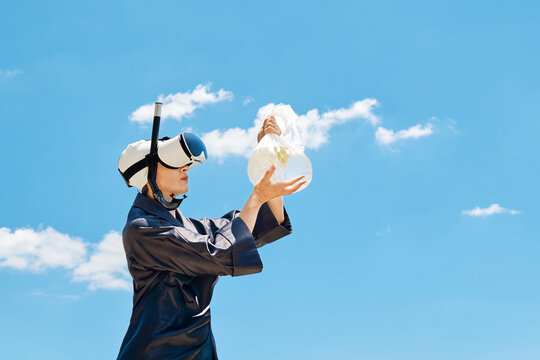 Woman in VR headset holds a plastic bag with a fish