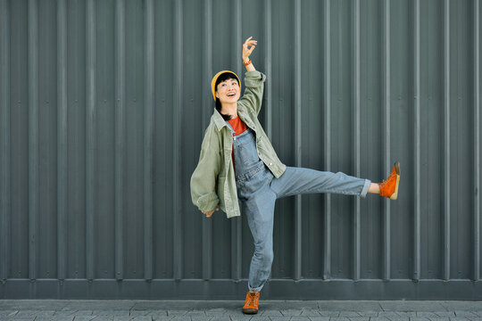 Laughing woman in casual urban outfit posing energetically outdoors