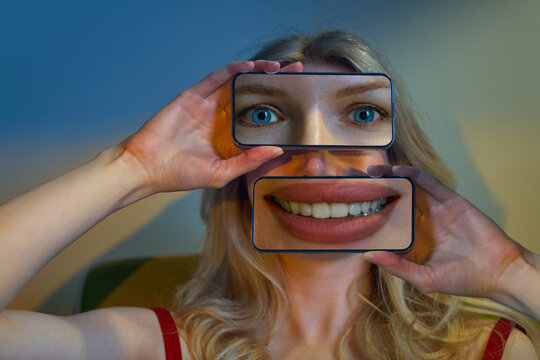Woman holds smartphones over her face showing digital identity