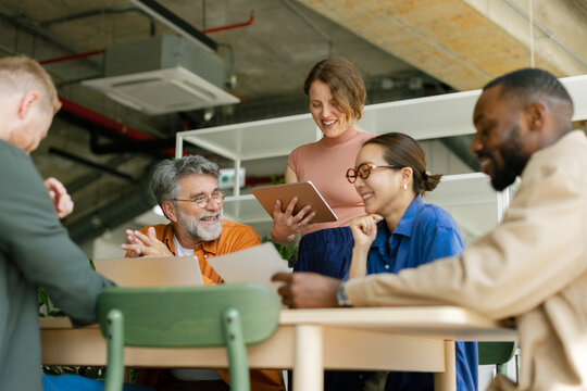 Smiling business team watches a tablet presentation at the office