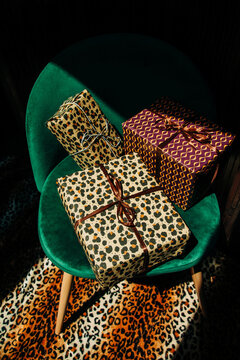 Stylish holiday gifts sit on a green armchair