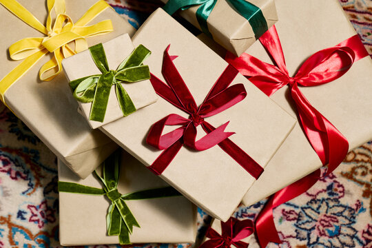 A pile of wrapped gifts rests on a Persian carpet