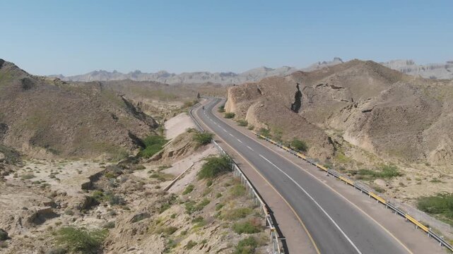 Aerial view of the Makran Coastal Range highway winding through the arid, rocky landscape of Balochistan, Pasni, Balochistan, Pakistan.