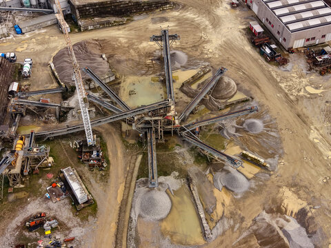 Aerial view of an aggregate processing facility with conveyor systems separating sand and gravel for construction in Milan, Lombardy, Italy.