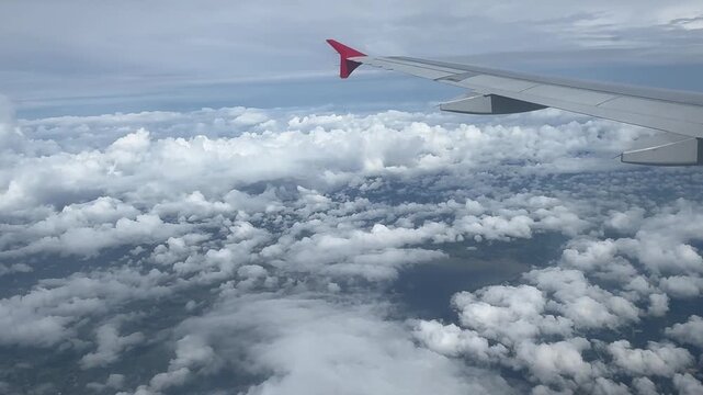 Beautiful window view while traveling by an airplane above the clouds.