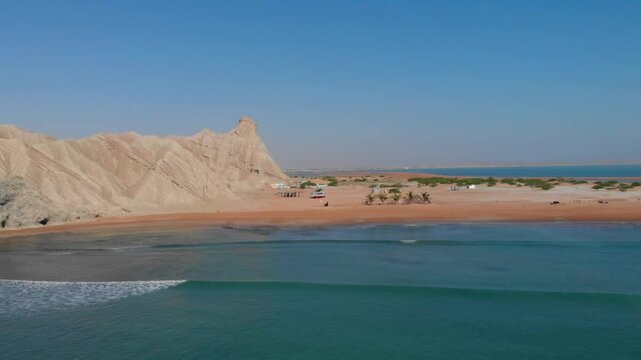 Aerial view of Makran Coastal Highway along the rugged coastline with sandy beaches and turquoise waters in Balochistan, Pakistan.
