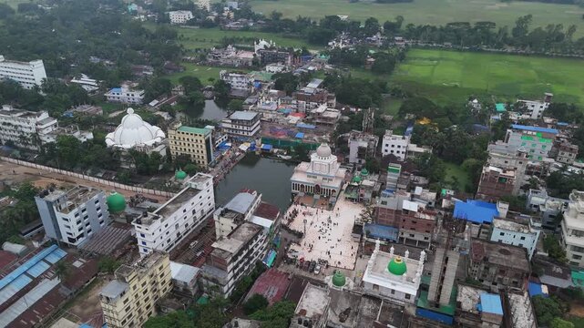 Aerial view of Maizbhandar Darbar Sharif complex with its white domes, surrounding buildings, and a central pond in Fatikchhari Upazila, Chittagong Division, Bangladesh.