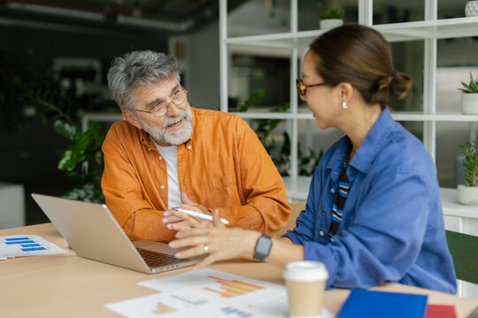 Businessman and businesswoman discuss finance charts at the office