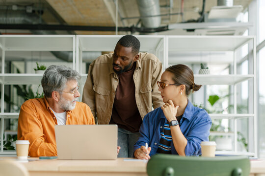Businessman and businesswoman discuss finance on laptop in office