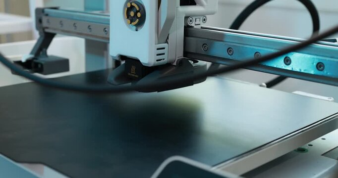 Close-up of an automated machine head moving over a flat work surface in a modern industrial setting, precision, technology, and clean manufacturing.