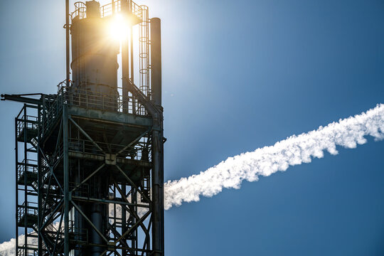View of an industrial structure at Parque das Nacoes with a contrail in the clear blue sky in Lisbon, Lisbon, Portugal.