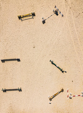Aerial view of equestrian show jumping obstacles arranged on a sandy training arena in Cascais, Lisbon, Portugal.