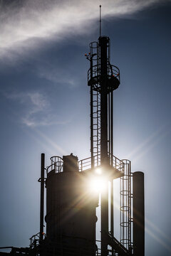 View of the industrial tower at Parque das Nacoes silhouetted against a bright sun with metal ladders and railings in Lisbon, Lisbon, Portugal.