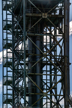 View of the intricate steel framework and industrial structures of the Parque das Nacoes, with metal beams and pipes against a blue sky in Lisbon, Lisbon, Portugal.