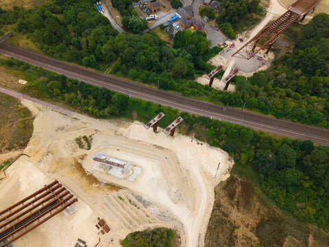 Aerial view of the Grantham Southern Relief Road bridge construction site featuring steel girders, concrete pillars, and earthworks near the railway tracks in Grantham, England, United Kingdom.
