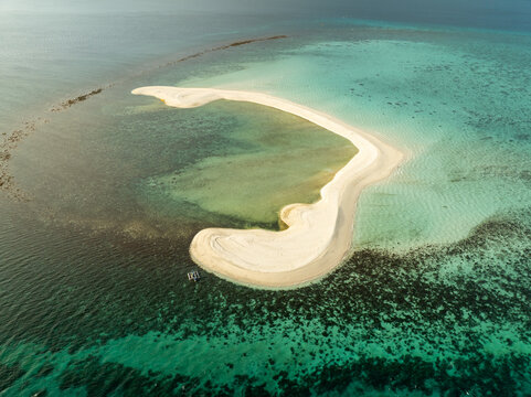 Aerial view of White Island sandbar surrounded by turquoise waters and coral reefs in Mambajao, Camiguin, Philippines.