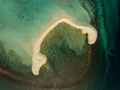 Aerial view of White Island, a pristine sandbar surrounded by turquoise waters and coral reefs in Mambajao, Camiguin, Philippines.
