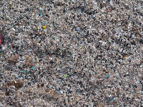 Aerial view of TPA Suwung landfill showing vast piles of mixed waste and plastic debris in Kecamatan Denpasar Selatan, Bali, Indonesia.