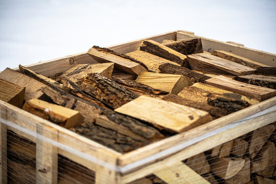 View of chopped firewood stacked in a wooden crate in Latvia.