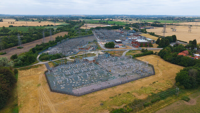 Aerial view of Staythorpe Power Station electrical substation with complex infrastructure, transformers, and power lines surrounded by rural fields and trees Staythorpe, England, United Kingdom.