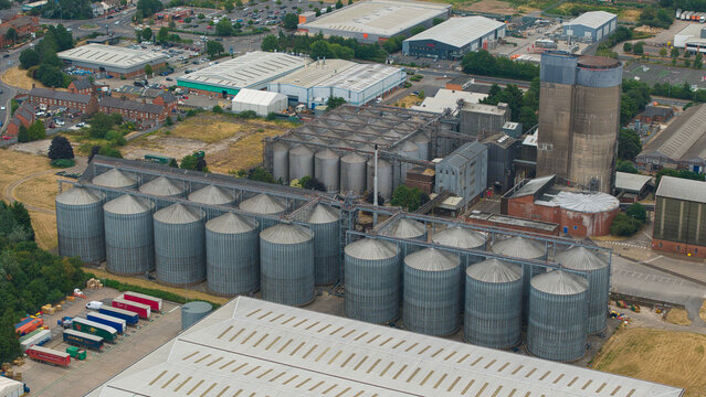 Aerial view of the industrial grain silo facility with large metal storage tanks and surrounding warehouses in Burton upon Trent, England, United Kingdom.