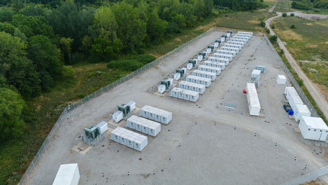 Aerial view of the National Grid Bustleholme Substation featuring rows of white lithium ion battery energy storage system containers in a fenced compound in Walsall, England, United Kingdom.