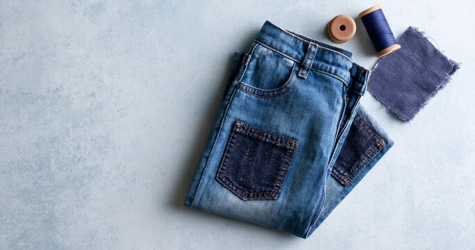 Blue denim jeans with sewing supplies