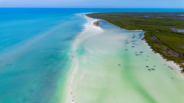 Aerial view of the white sandbar of Holbox surrounded by turquoise waters and lush mangroves in Holbox, Quintana Roo, Mexico.