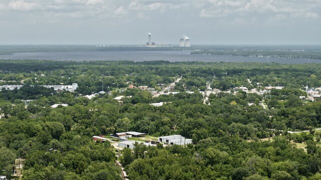 Aerial view of the lush green landscape surrounding Palatka, featuring dense forests and the Seminole Generating Station power plant in Palatka, Florida, United States.