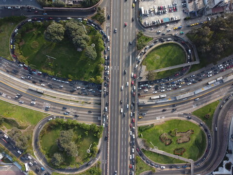 Aerial view of Javier Prado Este highway interchange with heavy traffic, multi-lane roads, and green cloverleaf landscaping in San Isidro, Provincia de Lima, Peru.