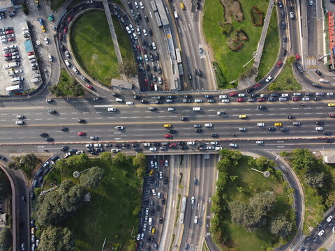 Aerial view of the Javier Prado Este highway interchange with heavy traffic on multi-lane roads, surrounded by green spaces and urban infrastructure in San Isidro, Provincia de Lima, Peru.