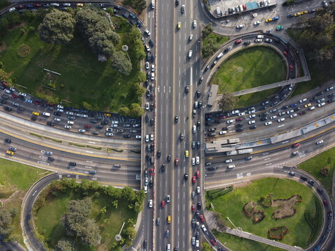 Aerial view of the Javier Prado Este highway interchange with heavy traffic flowing through multi-lane roads surrounded by green urban parks in San Isidro, Provincia de Lima, Peru.